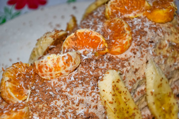 Cake with banana and tangerines, sprinkled with chocolate.