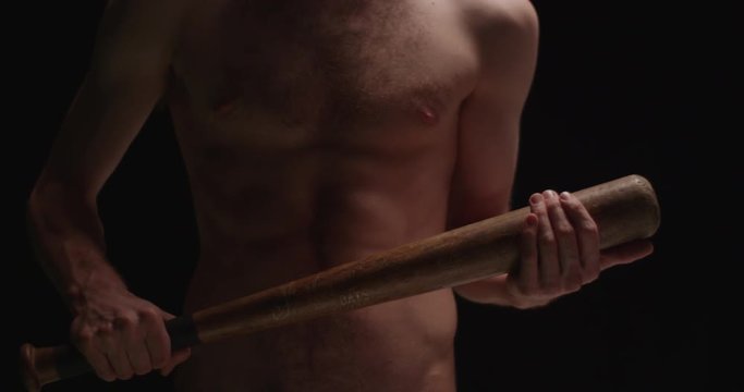 Man with bat nude no shirt abstract intimidating ready to fight in slow motion