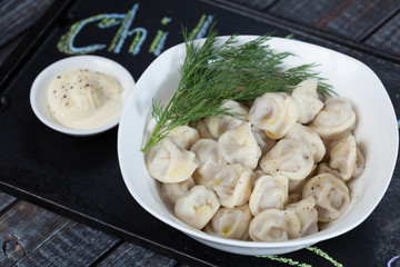 real, delicious, Russian dumplings on the table, with fresh herbs and spices, for cooking design.	