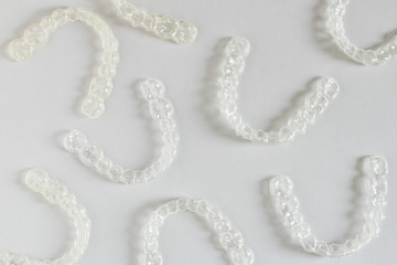 Top view of invisalign braces or invisible retainers on grey background, new orthodontic equipment