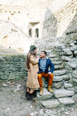Fototapeta na wymiar A beautiful couple travels to the sights of Georgia. Love story in nature with the fortress.