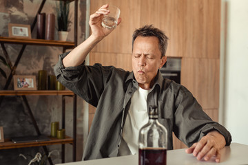 Resolute short-haired battered man ruining his life with alcohol