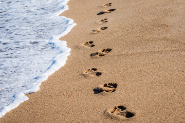 Foot Prints next to the ocean shoreline