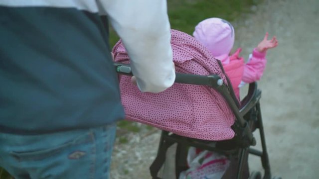 A young man walks with a small child in a stroller, Muscovite is carrying a stroller with his child.