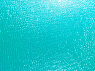 Obraz na płótnie Canvas Aerial view of a Crystal clear sea water texture. View from above Natural blue background. Turquoise ripple water reflection in tropical beach. Blue ocean wave. Summer sea. Drone. Top view