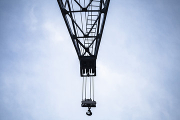 Fototapeta na wymiar Crane boom with hook under blue sky