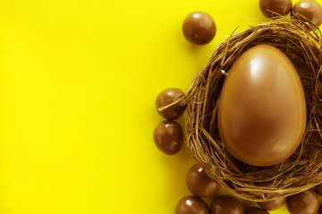Chocolate eggs in bird nest , Easter holiday decorations , Easter concept background. Eggs hunt.