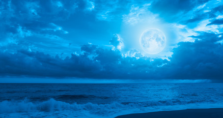Fototapeta na wymiar Night sky with moon in the clouds with dark sea 