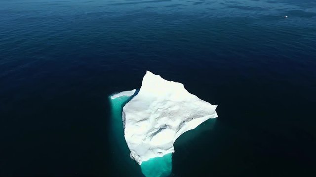 Beautiful aerial shot of an enormous ice berg 70 nautical miles off of the coast of Labrador. Ocean extending as far as the eye can see, pure bliss.