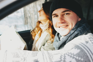 The happy couple of young man and woman in the car with paper map. Travel love story