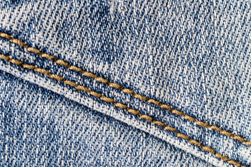 Denim texture closeup with seams. The image is suitable as a background for various tasks.