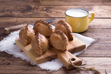 Russian traditional rye pies with egg, kokurki, on a wooden table