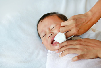 Mother use finger to clean tongue and baby's teeth with clean gauze.