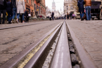 Fototapeta na wymiar The tramway rails in the middle of the old cobblestone in the city