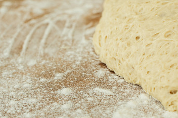 dough lying on a wooden cutting board sprinkled with flour