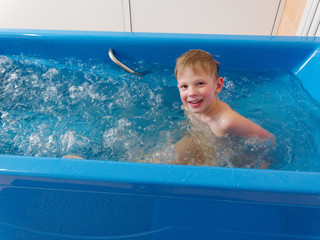 baby boy is taking a bath with bubbles. Jacuzzi bubble bath procedure.
