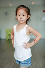 Adorable little Asian kid girl with butterfly tattoo sticker on cheek and arms, Dress up tattoos.