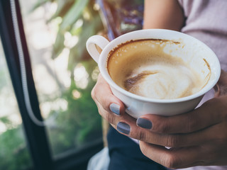 Woman hands holding a white hot coffee cup