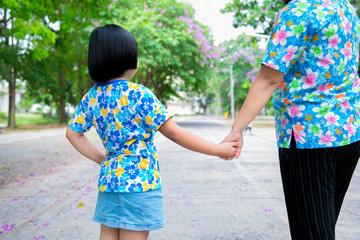 Mom walked in hand in the park.