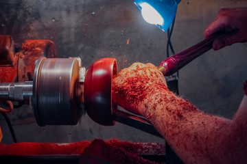 Carpenter working on a lathe close-up. Wood processing