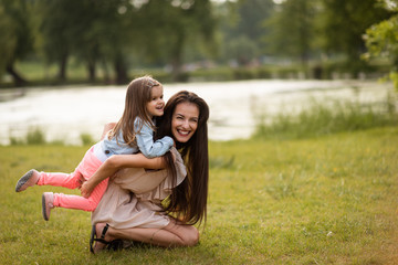 Young laughing woman with daughter in park