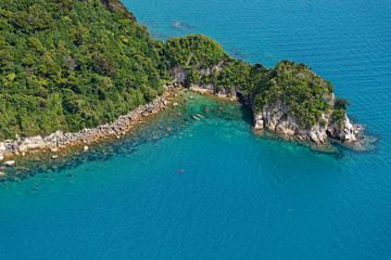 Fototapeta premium Bush clad hills reach down to the sea in New Zealand's Abel Tasman National Park