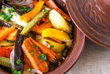 Vegetarian dish, homemade tajine or tagine with potatoes, eggplants, zucchini and pepper, close-up - traditional Moroccan and Tunisian cuisine