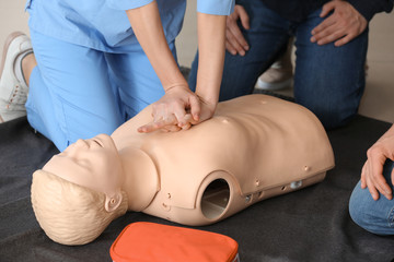 Instructor demonstrating CPR on mannequin at first aid training course