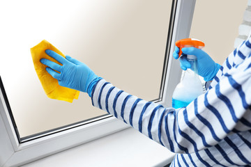 Woman washing window at home