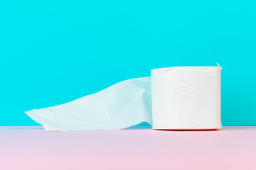 Toilet paper isolated on white table with blue background. Cleaning concept product