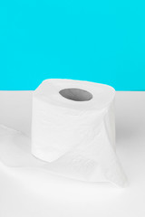 Toilet paper isolated on white table with blue background. Cleaning concept product