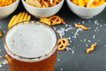 Lager beer and snacks on stone table. Cracker, chips side view