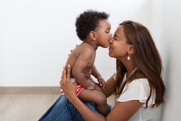 Cute baby biting his mother's nose