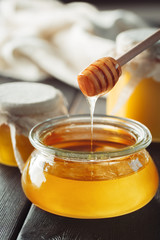 Honey background. Sweet honey in glass jar on wooden background.