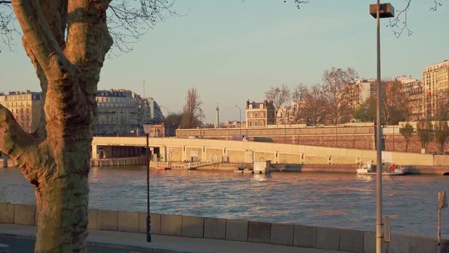 A wide angle of the riverside of the river Seine and the Jupiter Column at la Place de Bastille at sunset in Paris, France