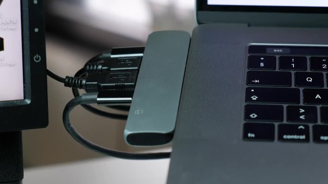 Footage of Satechi USB-C hub Space Grey adapter with Macbook Pro touchbar laptop for creative work.