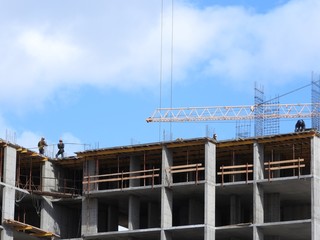 Fototapeta premium Large construction site, including several cranes working on the construction complex, with a clear blue sky.