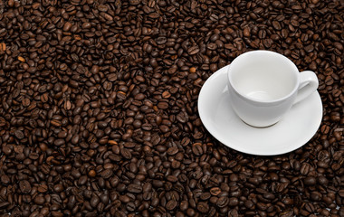 Ceramic white cup on the roasted coffee beans