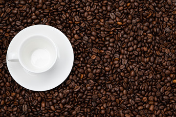 Roasted coffee beans arabica background with empty white cup 