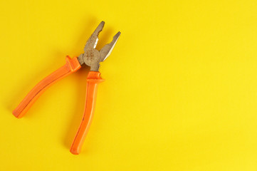 Pliers on yellow background
