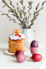 Easter cake and painted eggs. Easter composition with orthodox sweet bread, kulich and eggs on light background. Easter holidays breakfast