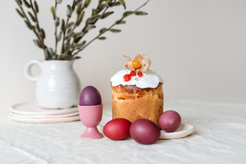 Fototapeta na wymiar Easter cake and painted eggs. Easter composition with orthodox sweet bread, kulich and eggs on light background. Easter holidays breakfast