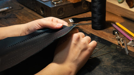 Leather handbag craftsman at work in a workshop