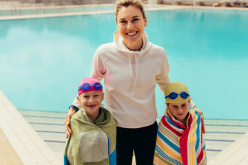 Obraz na płótnie Canvas Kids with coach at swimming pool