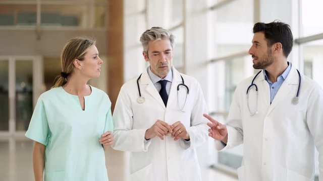 Doctors and nurse talking and walking in modern hospital