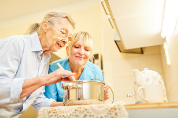 Fototapeta na wymiar Sozialdienst Frau und Seniorin in der Küche