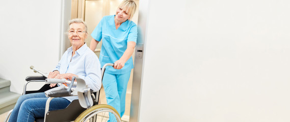 Alte Frau im Rollstuhl wird von Krankenpfleger betreut