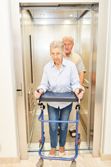 Zwei Senioren mit Gehhilfe in einem Lift