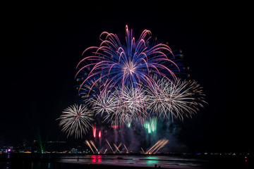 Amazing beautiful colorful fireworks display on celebration night, showing on the sea beach with...