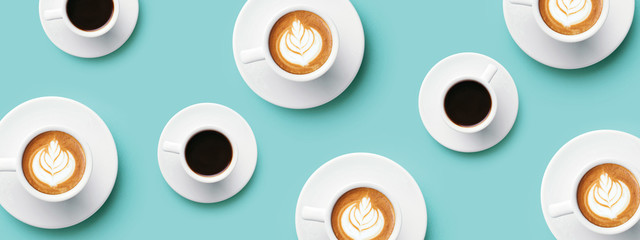 Many cups of coffee and cappuccino with latte art on turquoise background. Top view, banner for...